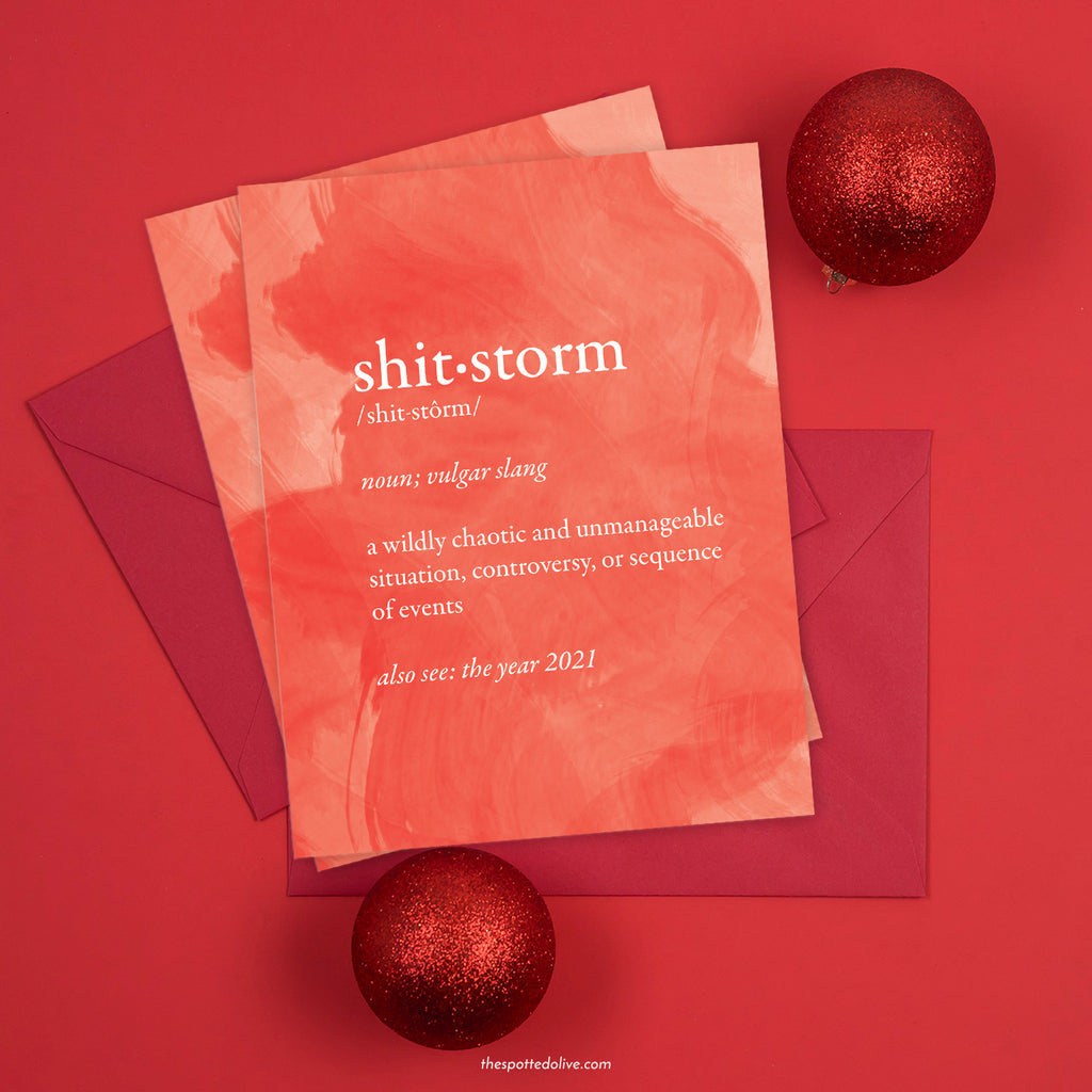 Shitstorm Holiday Cards with red envelopes on red background with holiday ornaments
